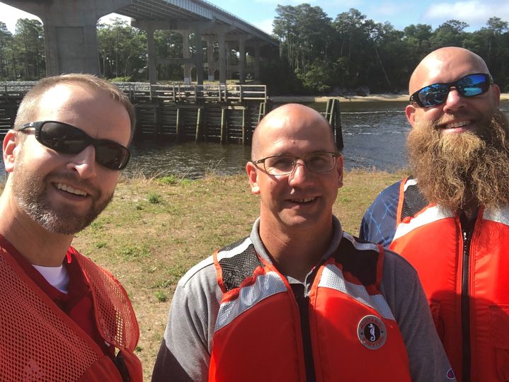 District Operations Leadership wearing life jackets by the water.