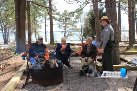 A Ranger at John H. Kerr speaks with a group of campers by their campfire.